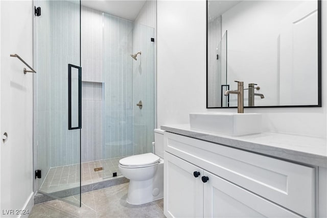 bathroom featuring tile patterned floors, vanity, toilet, and a shower with door