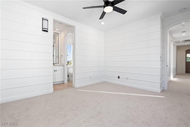 carpeted empty room with ceiling fan, a healthy amount of sunlight, and ornamental molding