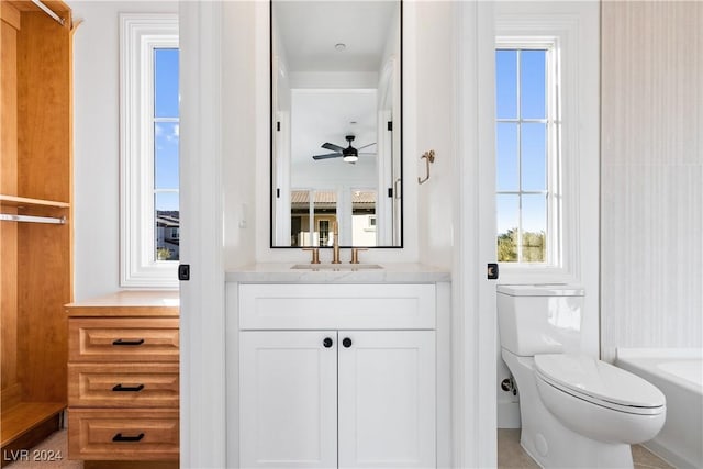 bathroom with a bathing tub, ceiling fan, tile patterned flooring, toilet, and vanity