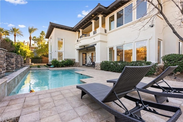 rear view of property featuring a balcony and a patio