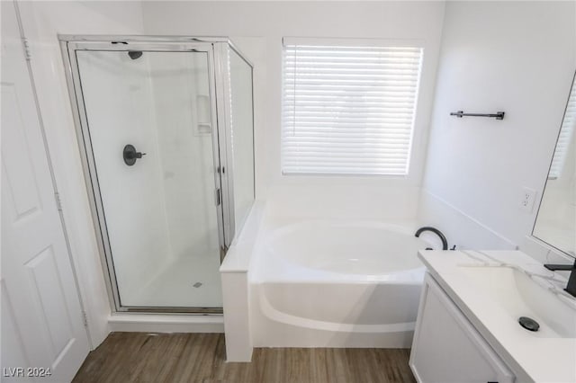 bathroom featuring plus walk in shower, hardwood / wood-style floors, and vanity