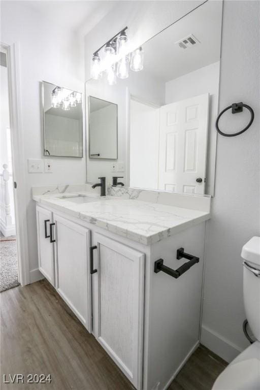 bathroom featuring hardwood / wood-style floors, vanity, and toilet