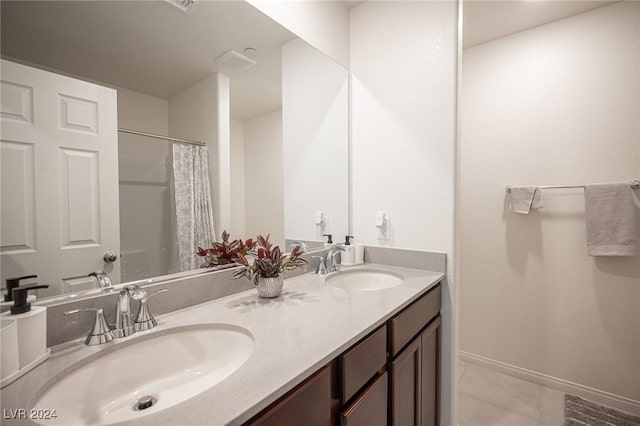 bathroom with tile patterned flooring, vanity, and walk in shower