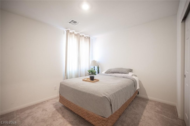 bedroom with light carpet and a closet