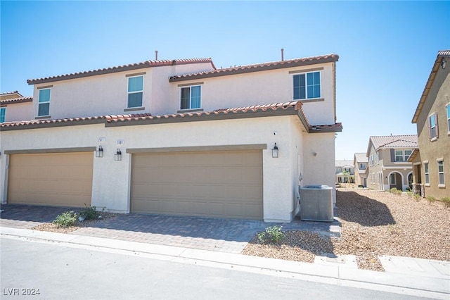 mediterranean / spanish-style house featuring a garage and central AC