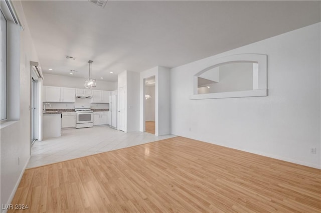 unfurnished living room featuring light hardwood / wood-style flooring and sink