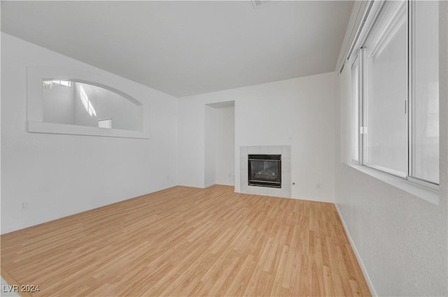 unfurnished living room featuring a fireplace, light wood-type flooring, and heating unit