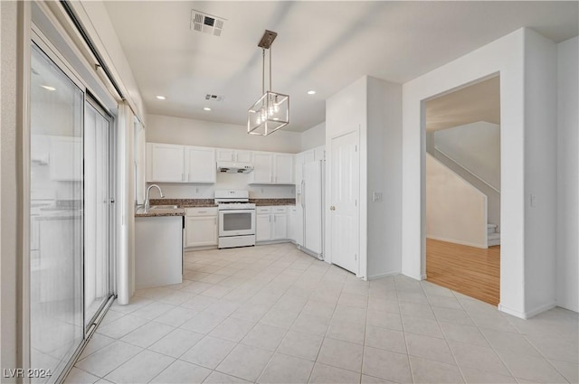 kitchen featuring white appliances, sink, white cabinetry, hanging light fixtures, and range hood