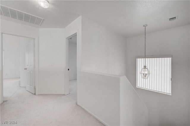 corridor featuring carpet and a textured ceiling