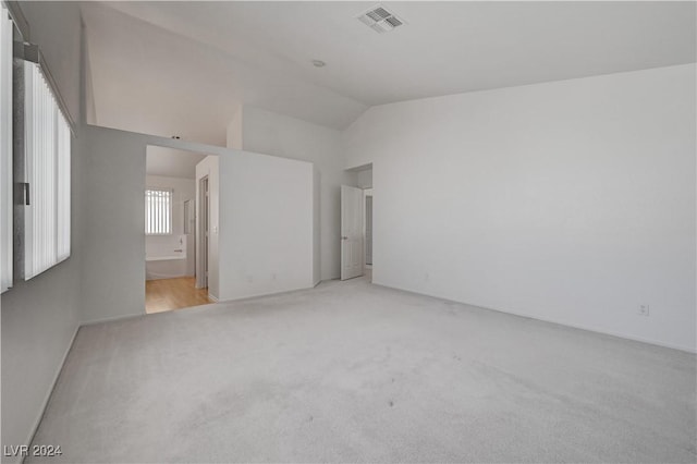 interior space featuring light colored carpet and lofted ceiling