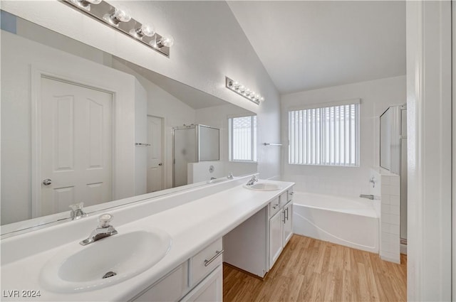 bathroom featuring vanity, hardwood / wood-style floors, separate shower and tub, and vaulted ceiling