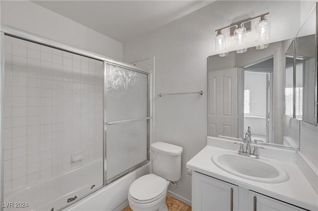 full bathroom with vanity, toilet, and enclosed tub / shower combo