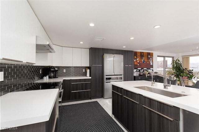 kitchen featuring decorative backsplash, stainless steel fridge, ventilation hood, sink, and white cabinets