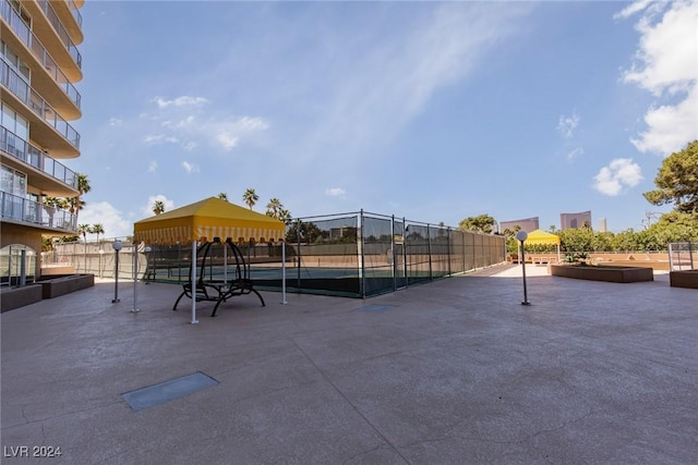 view of home's community featuring tennis court