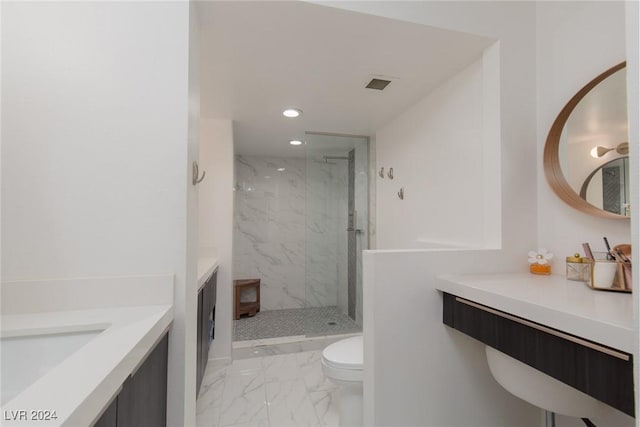 bathroom featuring toilet, a tile shower, and vanity