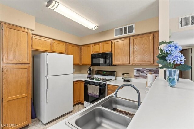 kitchen with sink, light tile patterned floors, and white appliances