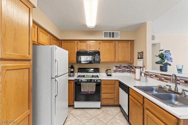 kitchen featuring light tile patterned floors, white appliances, backsplash, and sink