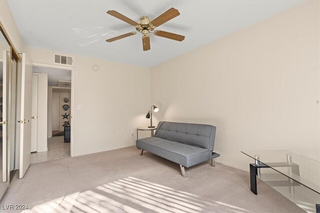 sitting room featuring light carpet and ceiling fan