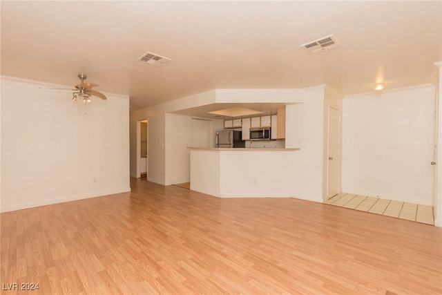 unfurnished living room featuring light hardwood / wood-style floors, ceiling fan, and crown molding