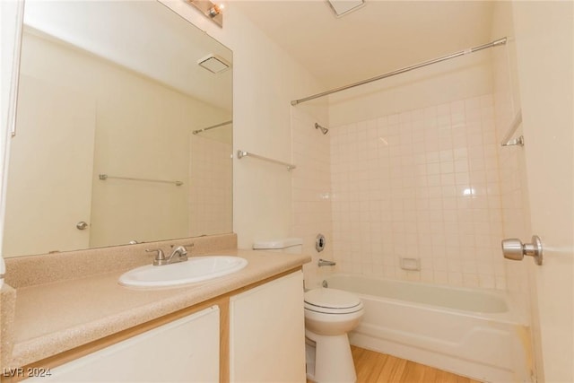 full bathroom featuring toilet, hardwood / wood-style floors, vanity, and tiled shower / bath