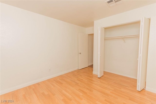 unfurnished bedroom with hardwood / wood-style flooring and a closet