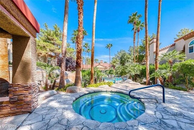 view of swimming pool featuring an in ground hot tub and a patio