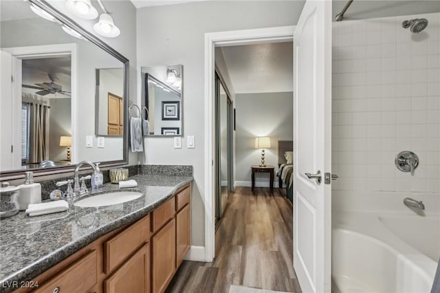 bathroom featuring ceiling fan, vanity, hardwood / wood-style flooring, and tiled shower / bath