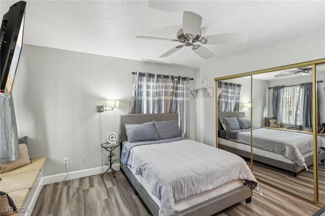 bedroom with ceiling fan, a closet, and wood-type flooring