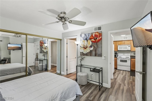 bedroom with ceiling fan, dark wood-type flooring, and a closet