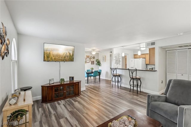 living room with ceiling fan and light hardwood / wood-style floors