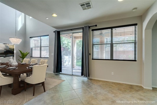 tiled dining room featuring an inviting chandelier