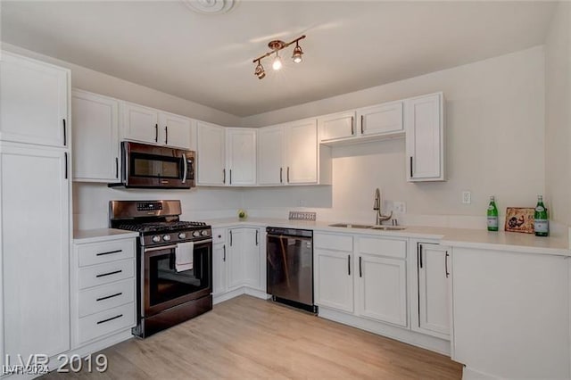 kitchen with white cabinetry, sink, stainless steel appliances, and light wood-type flooring