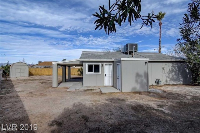 rear view of house with a storage unit and cooling unit