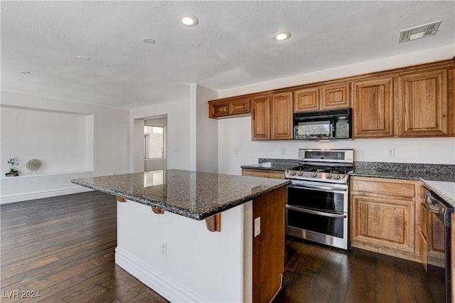 kitchen featuring dark hardwood / wood-style flooring, black appliances, dark stone counters, and a breakfast bar