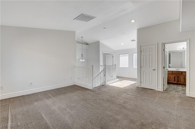 spare room with sink, carpet flooring, and vaulted ceiling