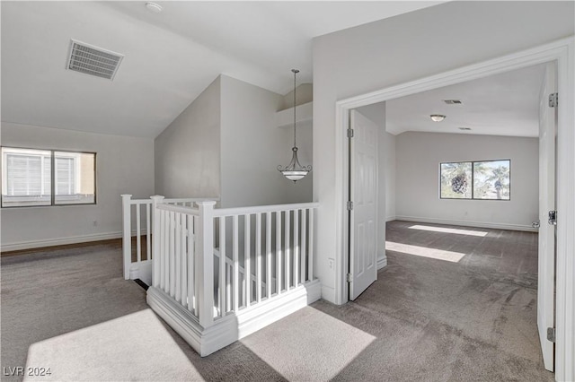 hallway featuring carpet floors and vaulted ceiling