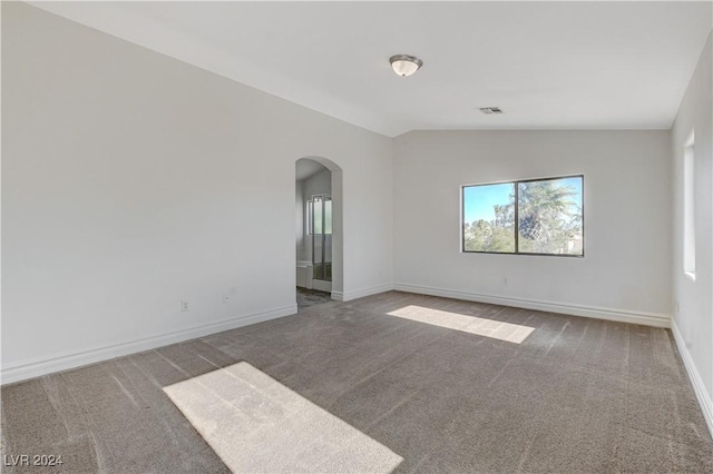 unfurnished room featuring vaulted ceiling and carpet