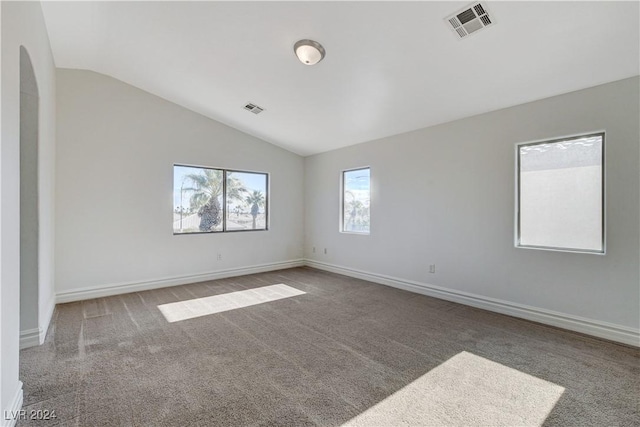 empty room with vaulted ceiling and carpet flooring