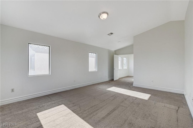 empty room featuring lofted ceiling and light colored carpet