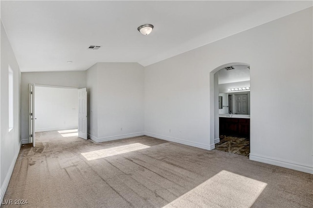 empty room with lofted ceiling and carpet flooring