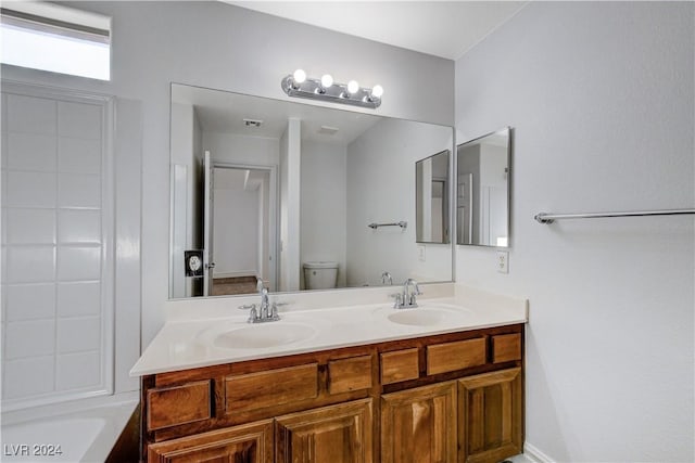 bathroom with vanity, toilet, and a washtub