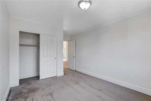 unfurnished bedroom featuring a closet and light carpet