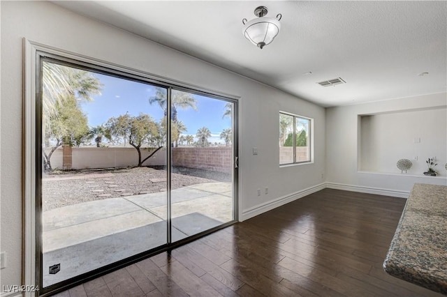 entryway featuring dark wood-type flooring and a textured ceiling