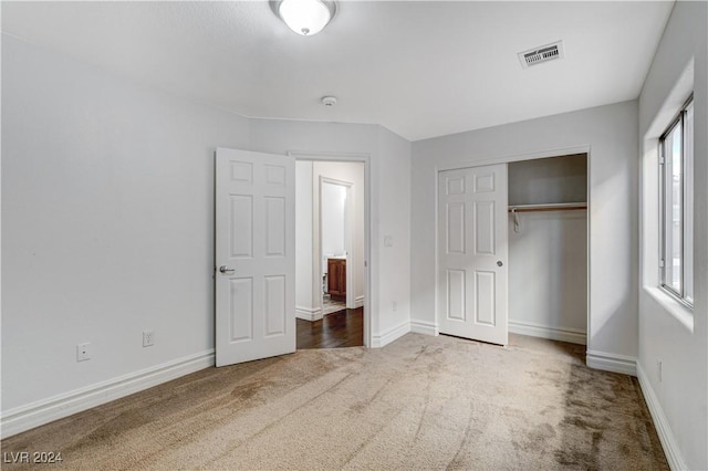 unfurnished bedroom featuring a closet and dark colored carpet