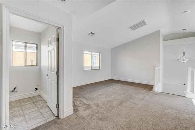 carpeted empty room with lofted ceiling