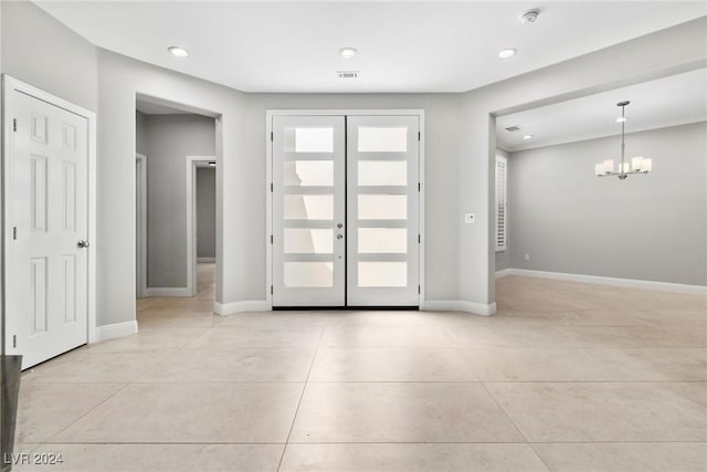 tiled entryway featuring a notable chandelier and french doors