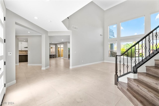 foyer featuring light tile patterned floors and a high ceiling