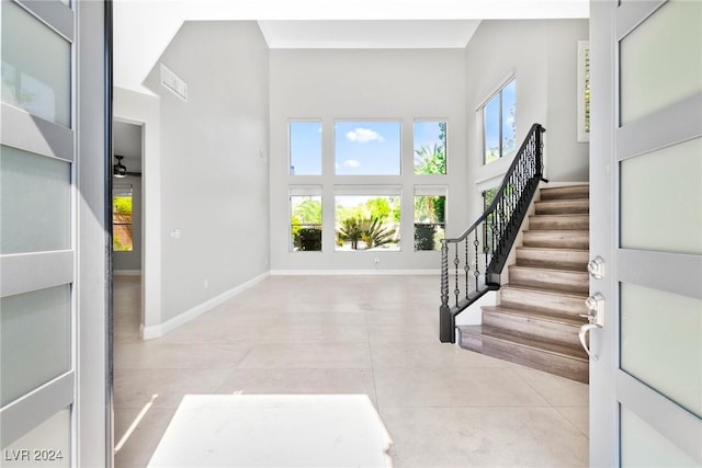 tiled foyer with a towering ceiling