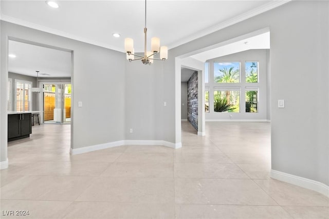 empty room with light tile patterned flooring, a chandelier, and ornamental molding