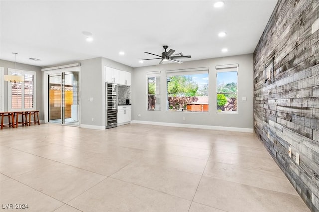 unfurnished living room featuring light tile patterned floors and ceiling fan